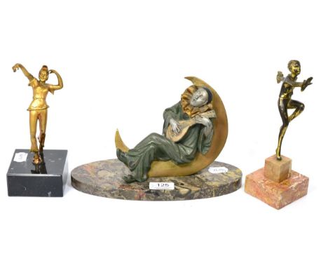 An Art Deco Spelter figure of a pierrot playing the mandolin sat on the moon, on an oval marble base, 17cm high 27cm wide (da