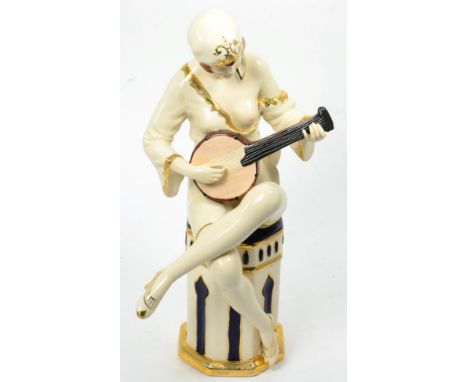 A Royal Dux Art Deco figure, modelled as a semi-clad woman seated playing a mandolin, impressed model 3027/H/10 and applied p