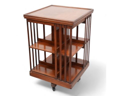 Edwardian mahogany revolving bookcase, square form with moulded top, two tiers with vertical moulded slats, on brass and cera