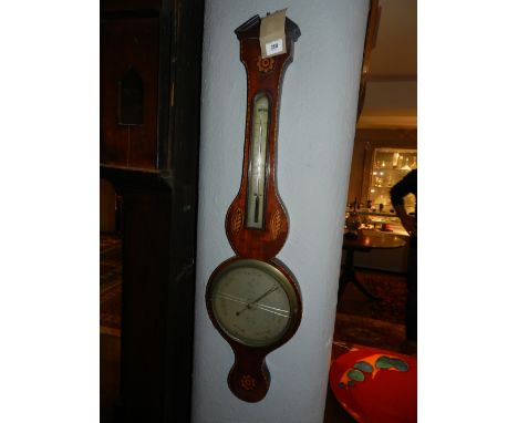 A late George III mahogany wheel barometer, having a broken pediment above floral and shell marquetry paterae, fitted silvere
