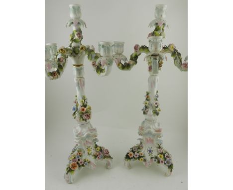 A pair of 20th century Dresden porcelain five light, four branch candelabrum in the Rococo style, encrusted with flowers, rai