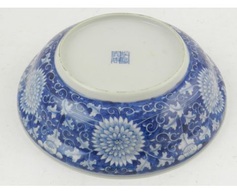 A Chinese late 19th century blue and white ogee bowl, decorated with flower emblems, bears a four character seal mark to base