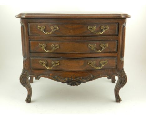 An early 20th century apprentice made beechwood miniature commode, in the Louis XV style, fitted three long drawers, raised o
