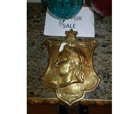 A commemorative brass wall plaque of Queen Victoria, relief decorated with a profile portrait of Queen Victoria. 