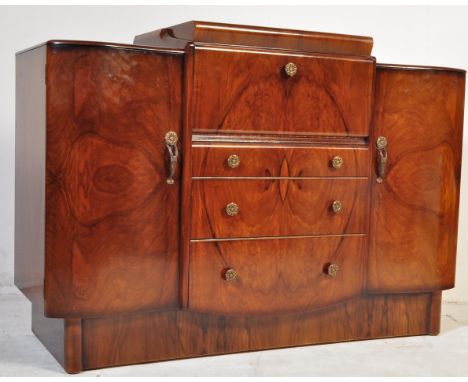 A mid 20th century circa 1950s Art Deco walnut veneer sideboard cocktail bar having a fall front panel opening to reveal a fu