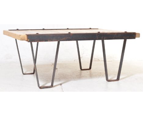 A vintage mid 20th century industrial cafe pine coffee table having pine panel top with metal hairpin supports. Measures 37cm