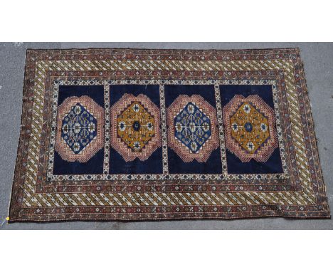 A 20th century Persian Islamic Ardebil rug carpet having four medallions to the central panel set within a geometrically patt