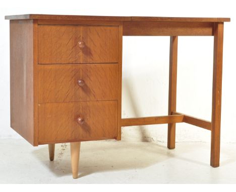 A vintage retro mid 20th century teak desk having a bank of three drawers aside a kneehole space, all being raised over squar