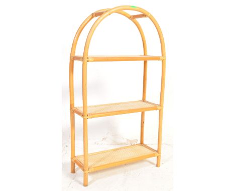 A vintage retro mid 20th century circa. 1970's bamboo and cane what-not having a bowed frame with cane shelves. Measures 99cm