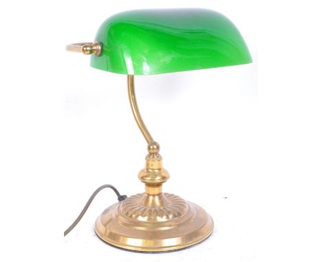 A vintage 20th century glass and brass bankers lamp having ombre green glass rectangular shade over brass base with gadrooned