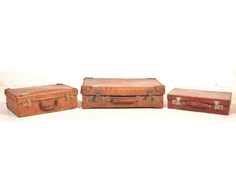 Three retro vintage 20th century leather suitcases / steamer trunks of various sizes. All having single handle to longer side