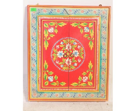 A vintage 20th century Indian painted door mirror having twin painted wooden doors with foliate decoration on red background&