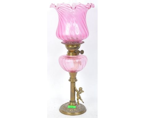 A 19th century Victorian Cranberry glass gas / paraffin lamp having a rippled shade, glass reservoir, raised on a Greek Colum