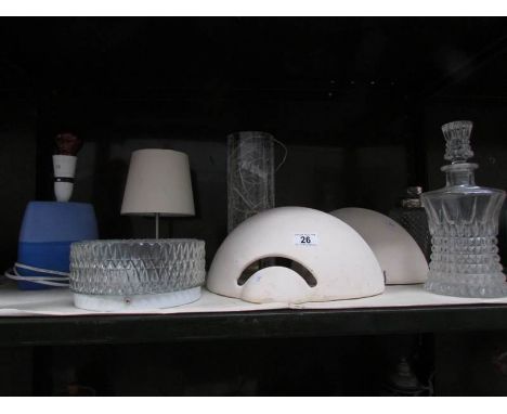 A shelf of assorted lighting and glass ware.