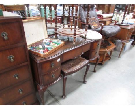 A dressing table with glass top and stool.