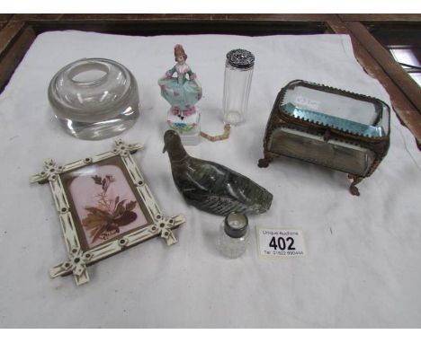 A French gilt and bevelled glass trinket box, a figure tape measure, glass inkwell etc.,
