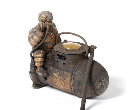 A Michelin Tyre Compressor, in the shape of an artillery shell surmounted by a painted cast aluminium figure of the Michelin 