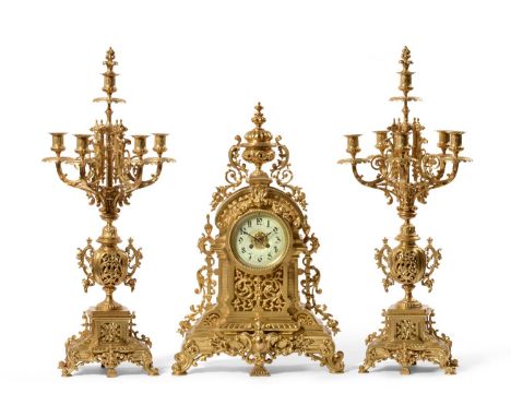 An Ormolu Striking Mantel Clock with Garniture, circa 1890, the elaborate case surmounted by an urn and with pierced and scro