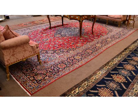 Kashan Carpet  Central Persia The blood red field of scrolling vines around an indigo pole medallion framed by spandrels and 