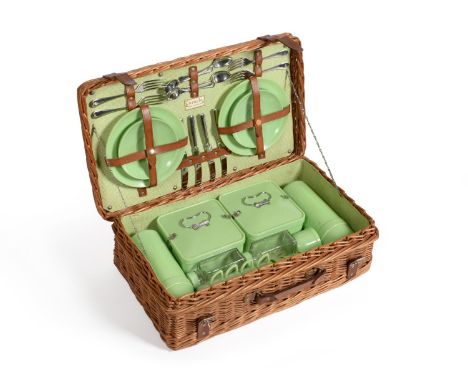 A Coracle Wicker Picnic Basket, circa 1950, containing green bandalasta settings for four persons, including teacups and sauc