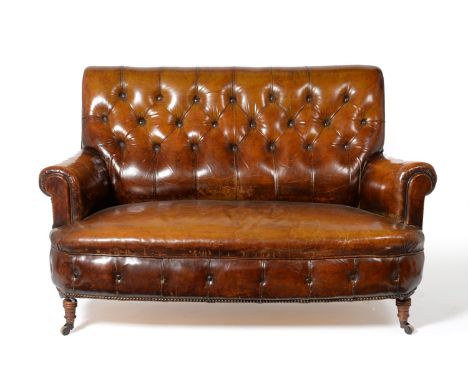 A Victorian Two-Seater Sofa, late 19th century, covered in vintage brown button leather, with rounded arm supports and overst