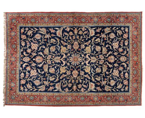 Ghom Carpet Central Persia The deep indigo field of large palmettes and scrolling vines enclosed by brick red borders of mean