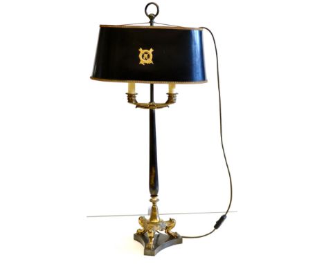 A Regency Style Gilt Metal Twin-Branch Bouillote Lamp, with painted oval shade below a brass carrying handle and tapering sup