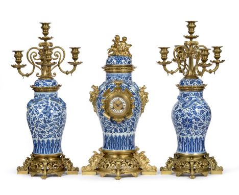 A Blue and White Porcelain and Gilt Metal Mounted Striking Mantel Clock with Garniture, circa 1880, vase shaped porcelain cas