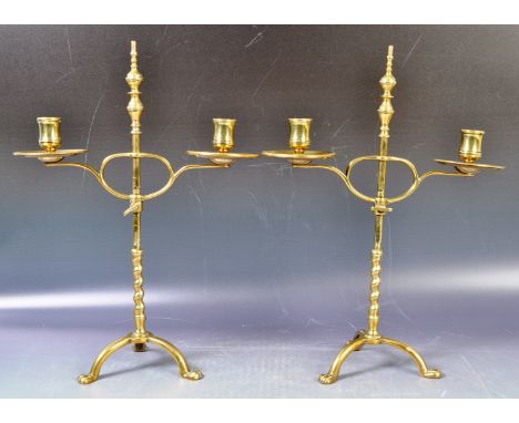 A pair of antique 19th Century Victorian polished brass rise and fall candlesticks comprising a central baluster finial twist