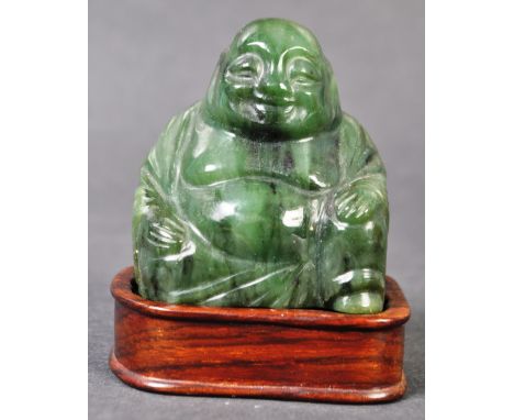 A 20th Century Chinese Republic period hand carved spinach green nephrite&nbsp;jade figurine of a smiling Buddha. The figure 