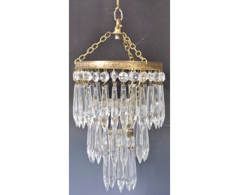 An antique early 20th Century Edwardian English brass and cut crystal glass hanging chandelier. Three hanging tiers with each