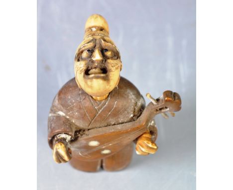 An antique 19th Century Japanese Meiji period oriental carved ivory and boxwood netsuke okimono figurine depicting an actor /