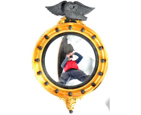 A vintage 20th Century English&nbsp;George III Regency style&nbsp;eagle adorned convex wall mirror. The circular mirror with 