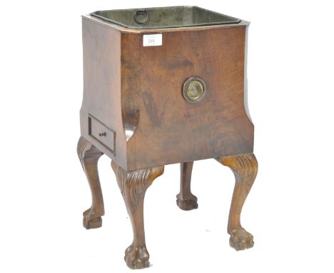 An antique 19th Century walnut wine bucket / champagne holder having an inset tin liner with canted sides and armorial brass 