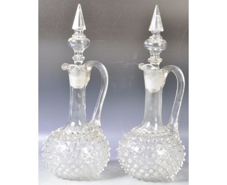 A pair of antique 19th Century Victorian glass hobnail decanters having a bulbous spiked glass base with shaped neck, folded 