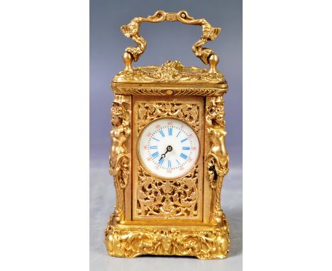 An antique early 20th Century French Palais Royale gilt brass ormolu miniature carriage clock having an ornate rococo influen