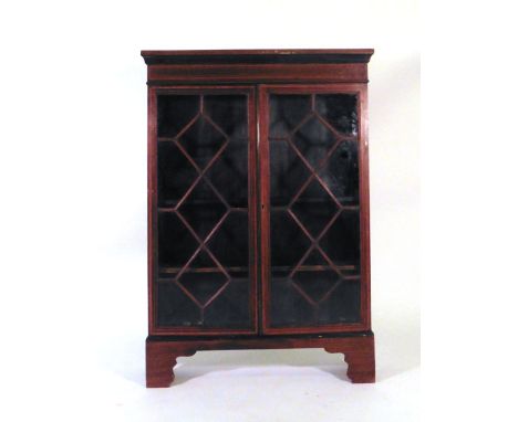 A late 19th/early 20th century mahogany and strung bookcase, the two astral glazed doors enclosing two adjustable shelves on 