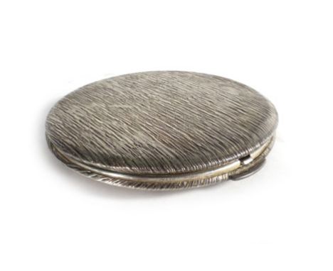 A silver compact of circular form decorated in a bark design, maker K Ltd., London 1972, d. 8 cm   CONDITION REPORT:  In need