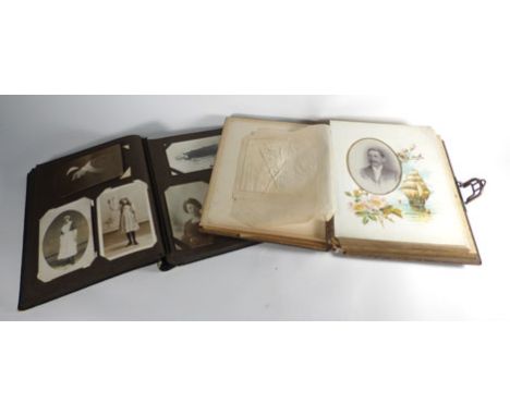 A musical photograph album together with three albums of early 20th century postcards including sweethearts cards, humorous g