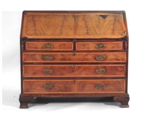 A 19th century walnut and mahogany bureau, the fall front enclosing a fitted interior over two short and three long graduated