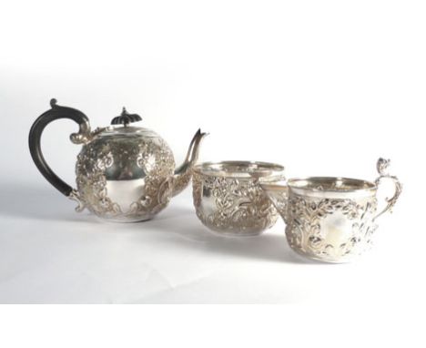 A late Victorian silver bachelor's teapot of globular form, repousse decorated with fruiting and flowering shrubs, together w