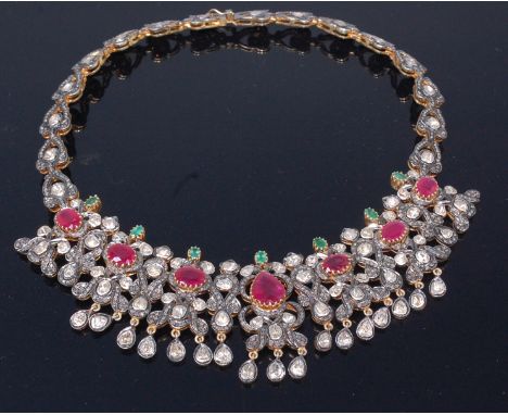 An antique yellow metal necklet, the pierced and stylised flower head links set with rough cut diamonds and six oval cut rubi