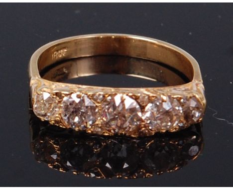 An 18ct gold and diamond five stone ring, the graduated old brilliants in a chased line setting, total diamond weight estimat