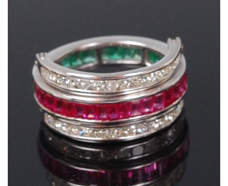 A contemporary 14ct white gold, ruby, emerald and diamond set triple eternity ring, the central band half set with baguette c