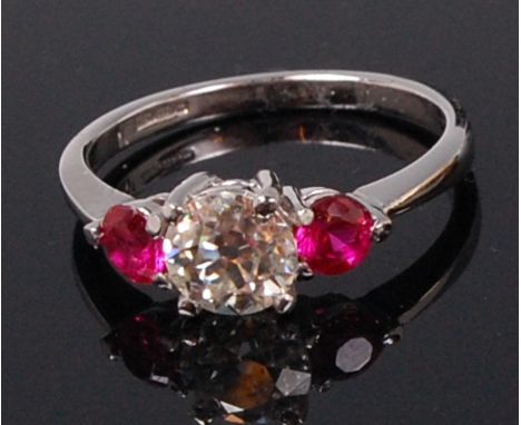 A platinum, ruby and diamond dress ring, the four claw set brilliant cut diamond weighing approx. 0.9ct, flanked to either si