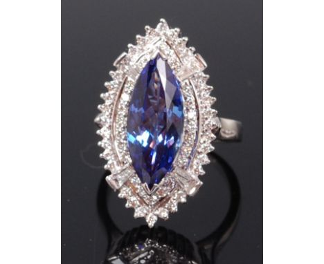 A contemporary 14ct white gold, tanzanite and diamond dress ring, the marquise cut tanzanite weighing 5.5ct in a two tier sur