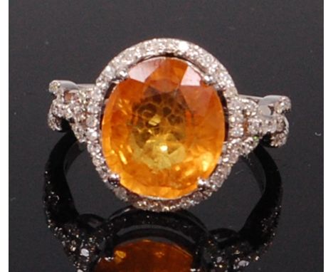 A contemporary 14ct white gold, yellow sapphire and diamond dress ring, the oval cut yellow sapphire weighing approx 5.75ct, 