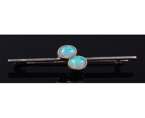 An Art Deco white metal and opal set bar brooch, the twin cabochon opals each weighing approx. 0.65ct, 5.2cm