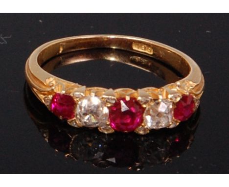 A yellow metal, ruby and diamond dress ring, arranged as three graduated claw set rubies, total weight estimated 0.75ct, disp