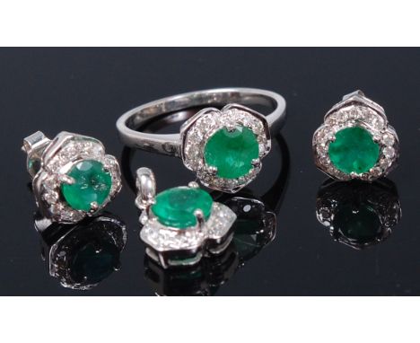 A contemporary white metal, emerald and diamond set garniture, comprising ring, matching pair of ear studs and pendant, each 